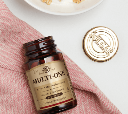 Solgar Multi-One multivitamin bottle on a white surface with a red cloth