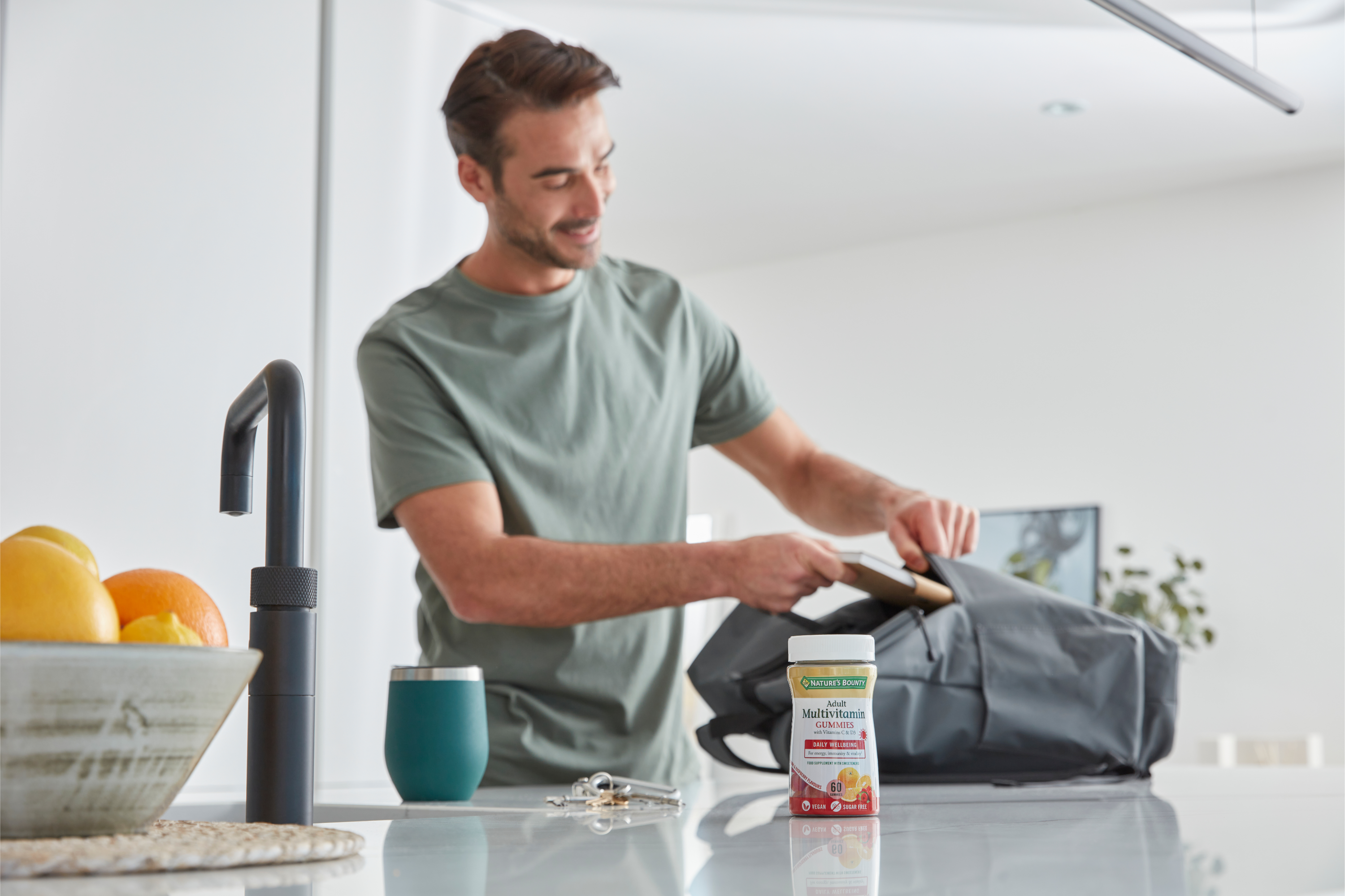 Man in a kitchen preparing food, with a container of Quaker Oats on the counter.